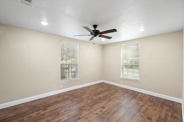 unfurnished room featuring ceiling fan, plenty of natural light, and dark hardwood / wood-style flooring