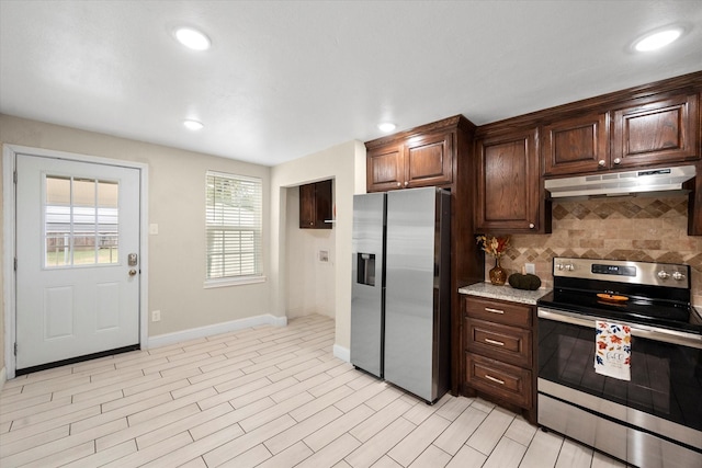 kitchen with stainless steel appliances, light hardwood / wood-style floors, dark brown cabinetry, and decorative backsplash