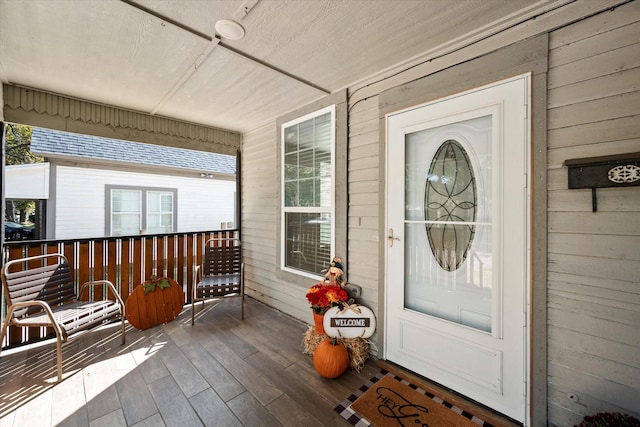 view of exterior entry featuring covered porch