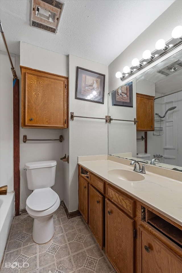 full bathroom with vanity, a textured ceiling, bathtub / shower combination, tile patterned floors, and toilet