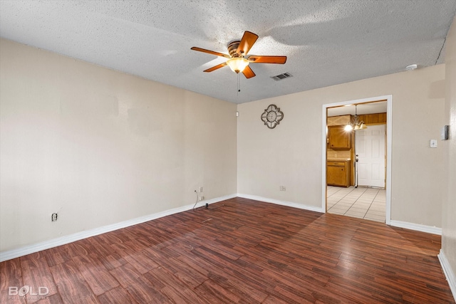 spare room featuring wood-type flooring, a textured ceiling, and ceiling fan