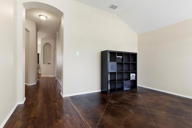 hall featuring lofted ceiling and dark hardwood / wood-style floors