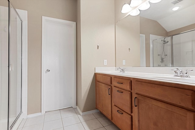 bathroom featuring lofted ceiling, vanity, tile patterned floors, and walk in shower