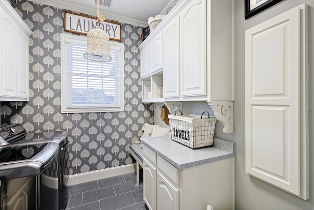 kitchen featuring white cabinetry, independent washer and dryer, ornamental molding, and dark tile patterned flooring