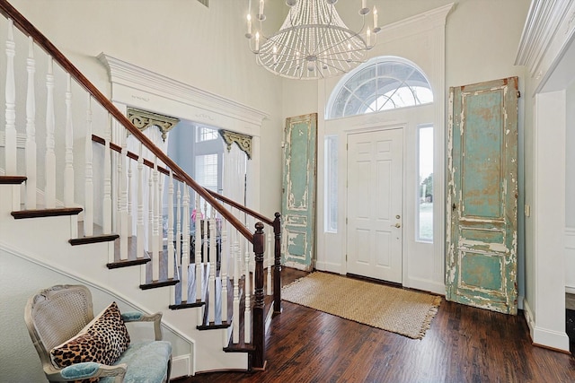 foyer entrance with dark wood-type flooring, an inviting chandelier, and a high ceiling