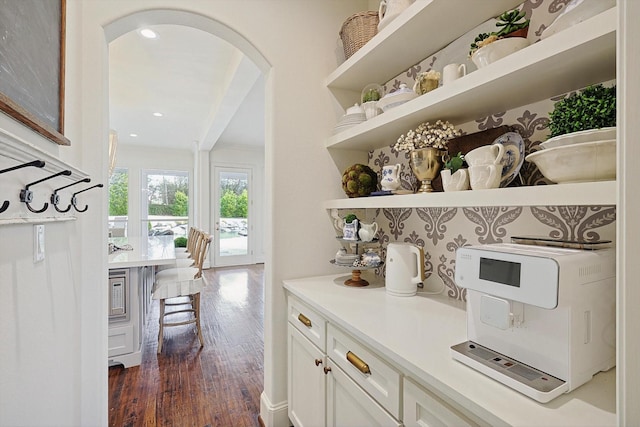 bar featuring white cabinetry and dark hardwood / wood-style flooring