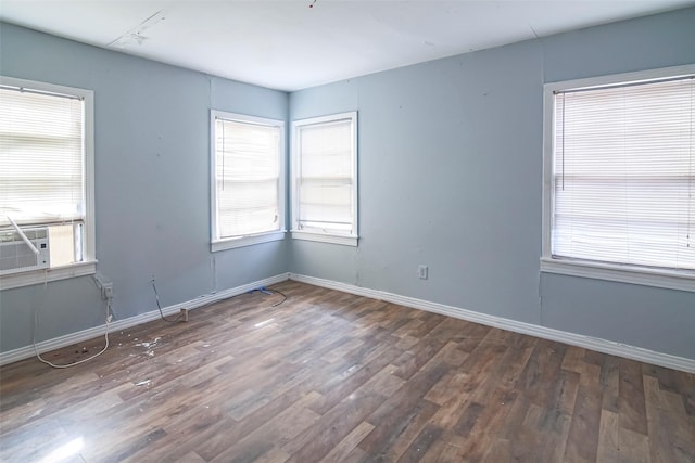 empty room with plenty of natural light and dark hardwood / wood-style flooring