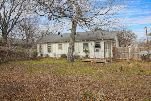 back of property featuring cooling unit and a yard