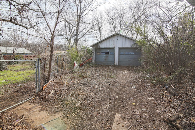 view of yard with a garage and an outbuilding