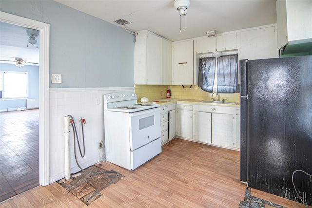 kitchen featuring electric stove, ceiling fan, white cabinets, and black fridge