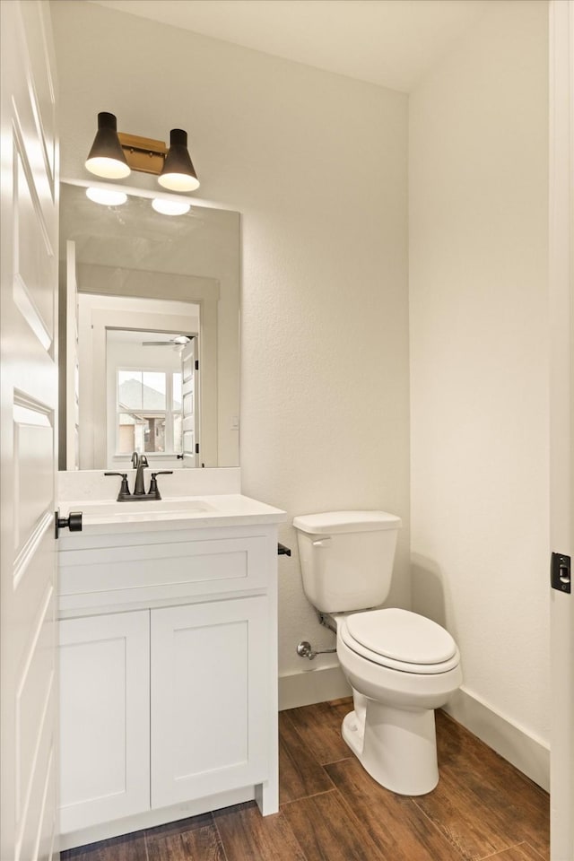 bathroom with vanity, hardwood / wood-style flooring, and toilet