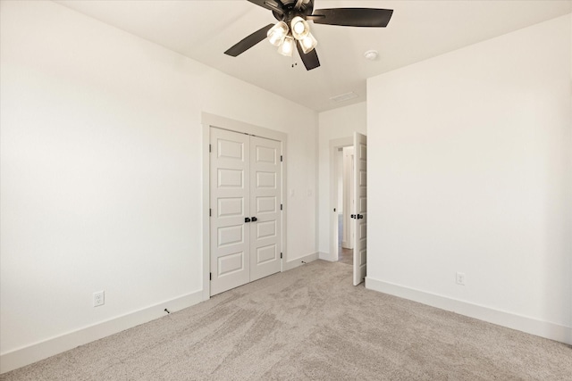 empty room featuring ceiling fan and light carpet