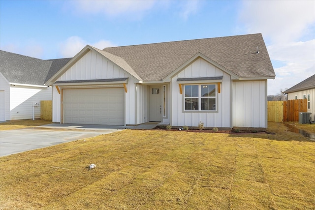 view of front facade with a garage, a front yard, and central air condition unit