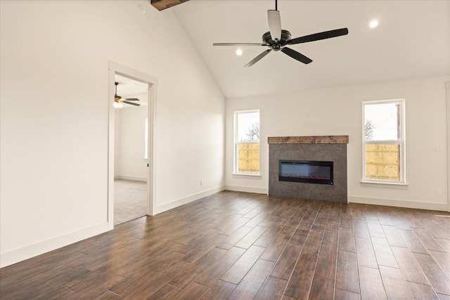 unfurnished living room with beam ceiling, plenty of natural light, dark hardwood / wood-style floors, and a fireplace