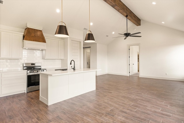 kitchen with white cabinets, custom exhaust hood, hanging light fixtures, a center island with sink, and stainless steel range oven