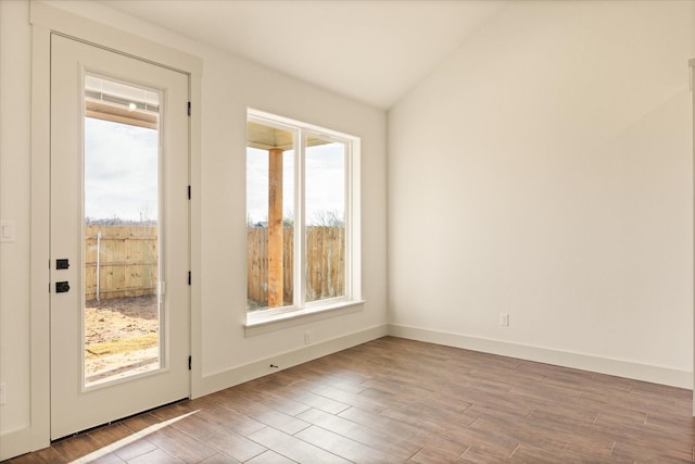 doorway to outside with hardwood / wood-style flooring, vaulted ceiling, and a wealth of natural light