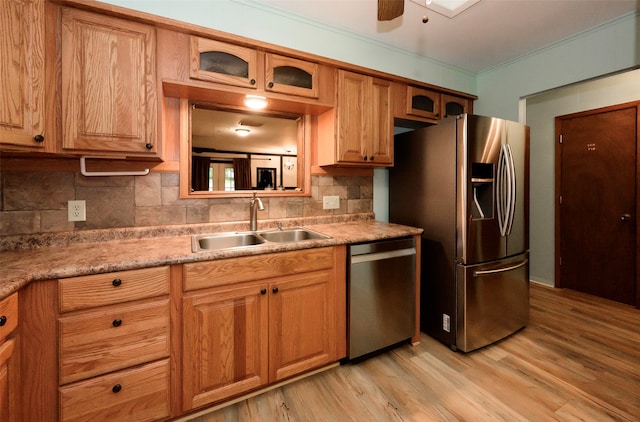 kitchen featuring stainless steel appliances, light hardwood / wood-style floors, sink, and backsplash