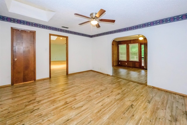 unfurnished room with ceiling fan, wood-type flooring, and a textured ceiling