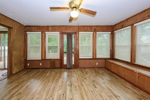 unfurnished sunroom featuring ceiling fan and a healthy amount of sunlight