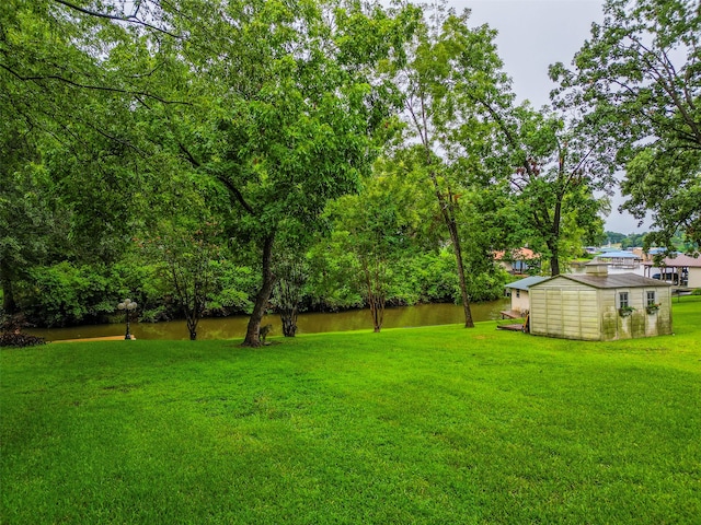 view of yard with a water view and a storage shed