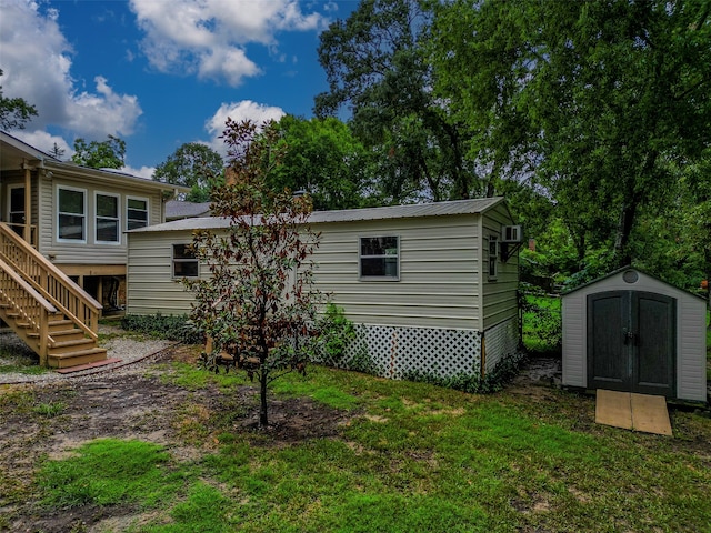 rear view of property featuring a lawn and a shed