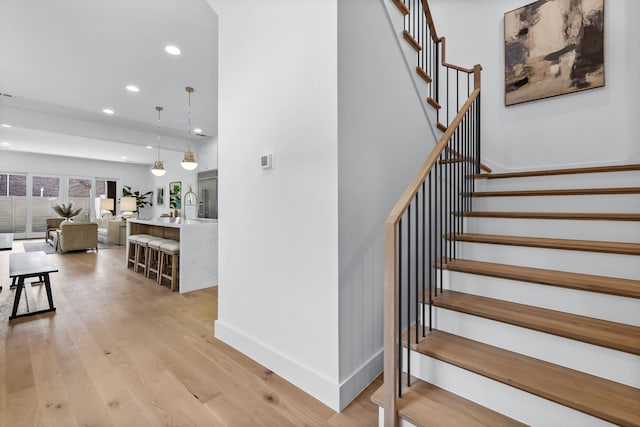 staircase featuring wood-type flooring and sink