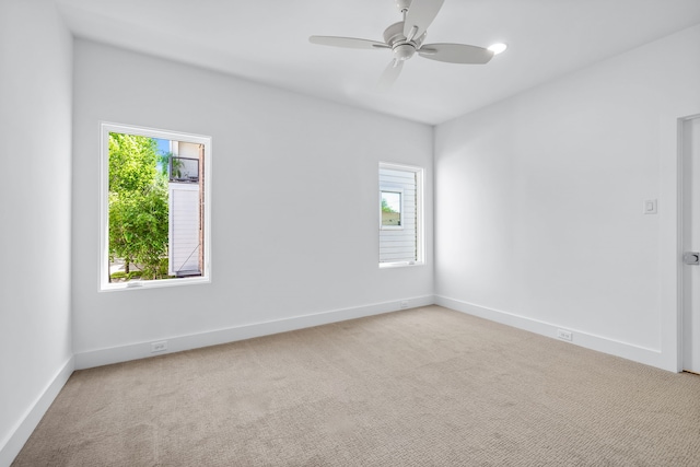 carpeted spare room with ceiling fan and a healthy amount of sunlight