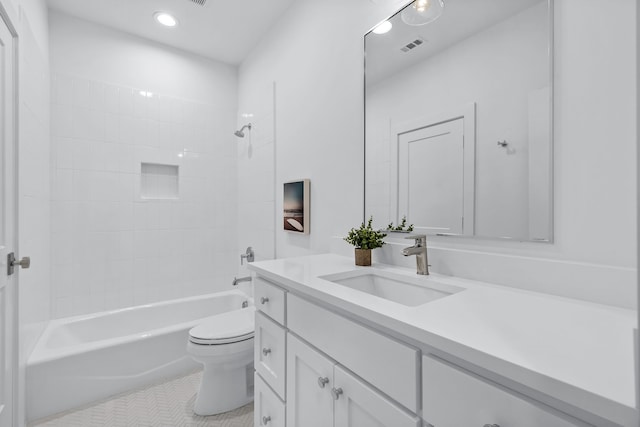 full bathroom featuring vanity, tiled shower / bath combo, tile patterned floors, and toilet