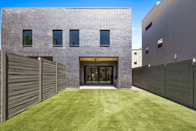 rear view of property featuring a lawn