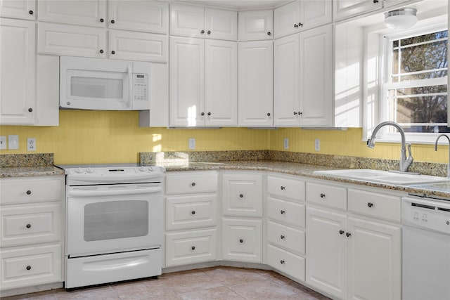 kitchen with white cabinetry, sink, and white appliances