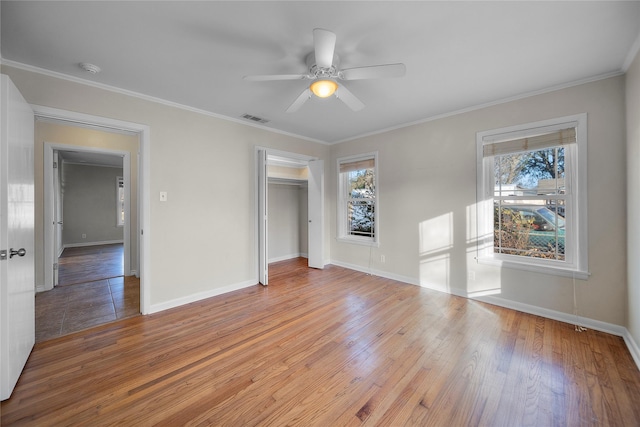 unfurnished bedroom featuring ornamental molding, a closet, and light wood-type flooring