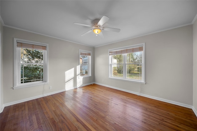 empty room featuring hardwood / wood-style flooring, ornamental molding, plenty of natural light, and ceiling fan