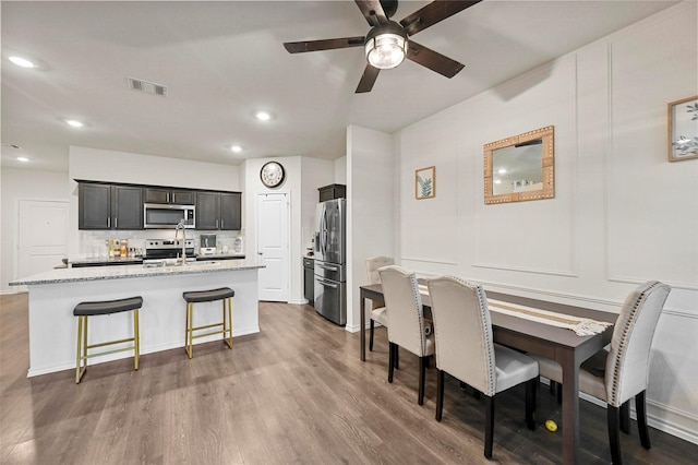 dining area with sink, dark hardwood / wood-style floors, and ceiling fan