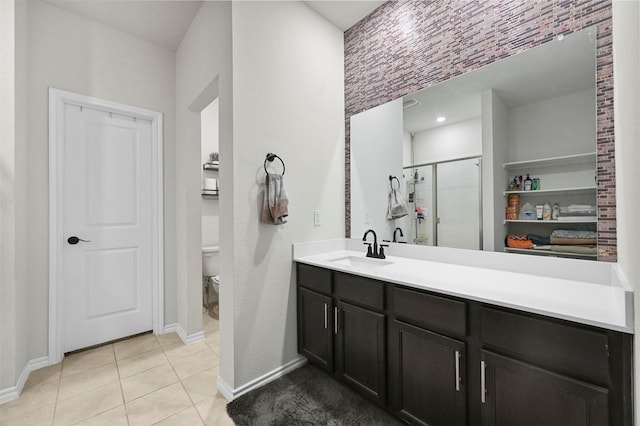 bathroom with an enclosed shower, vanity, tile patterned floors, and toilet