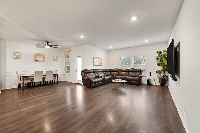 living room featuring ceiling fan and dark hardwood / wood-style flooring