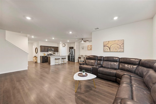 living room featuring ceiling fan and dark hardwood / wood-style flooring