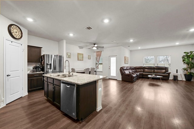 kitchen featuring sink, appliances with stainless steel finishes, dark brown cabinets, a center island with sink, and dark hardwood / wood-style flooring