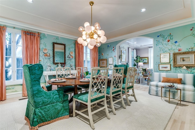 dining room with a notable chandelier, ornamental molding, and light hardwood / wood-style floors