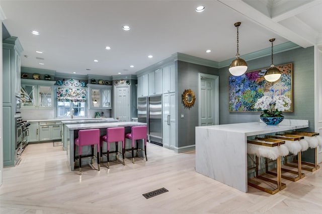 kitchen featuring high quality appliances, a center island, and a kitchen bar