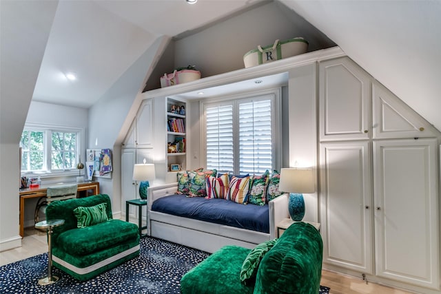 living room featuring lofted ceiling and light hardwood / wood-style floors