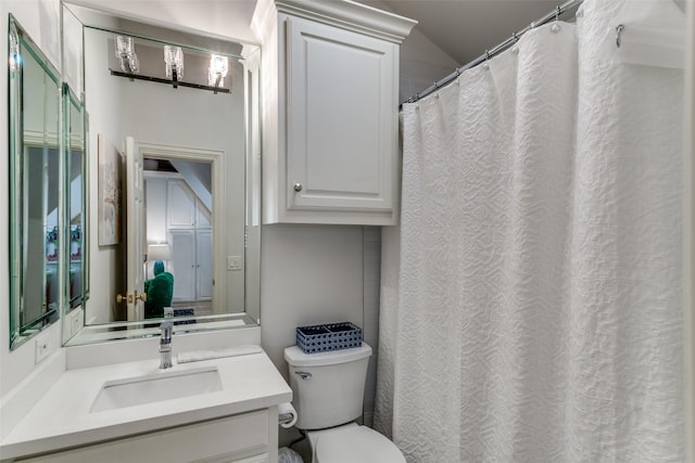 bathroom with lofted ceiling, vanity, and toilet