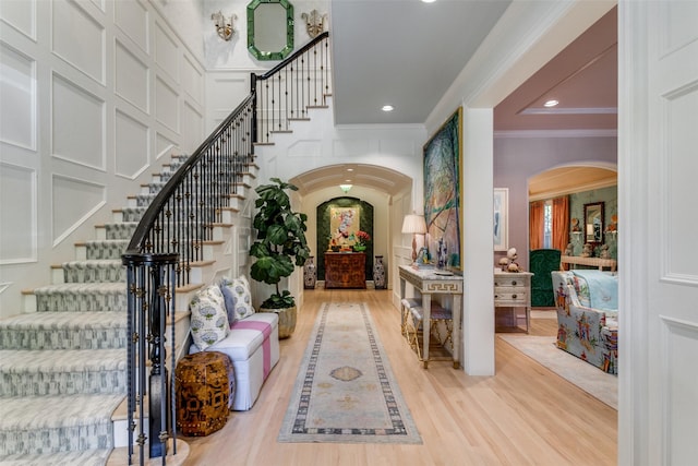 entrance foyer with crown molding and light wood-type flooring