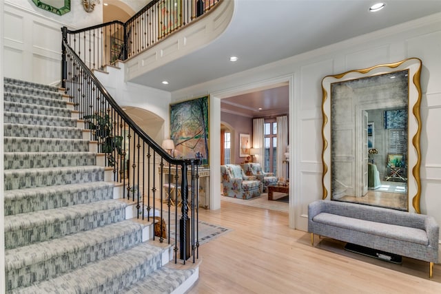 entrance foyer featuring ornamental molding and light wood-type flooring