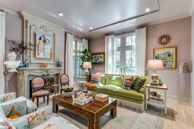 living area with french doors, ornamental molding, a high end fireplace, and light hardwood / wood-style flooring