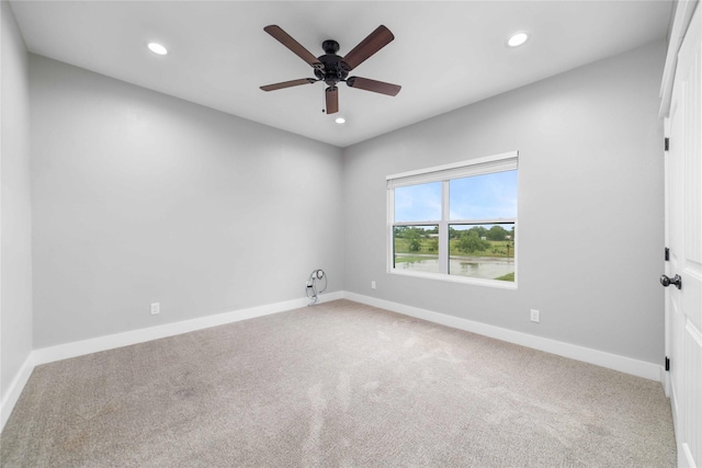 carpeted spare room with ceiling fan