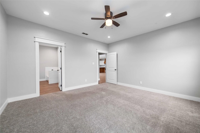 unfurnished bedroom featuring light carpet, ensuite bath, and ceiling fan