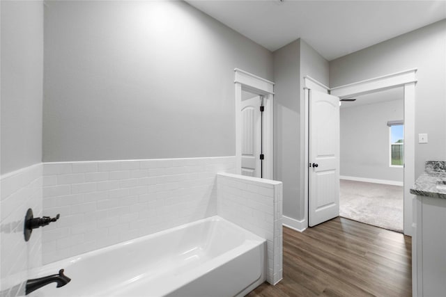 bathroom with vanity, hardwood / wood-style floors, and a washtub