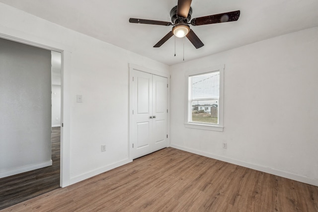 unfurnished bedroom featuring light hardwood / wood-style floors, a closet, and ceiling fan