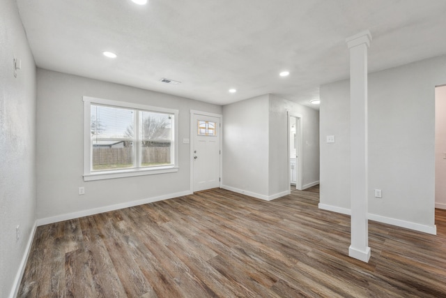 entryway with dark hardwood / wood-style flooring and ornate columns