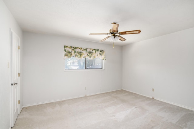 empty room featuring ceiling fan and light colored carpet